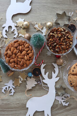 Various Christmas decorations, cookies, chocolate and nuts on wooden background. Flat lay.