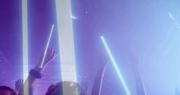 Crowd raising and waving hands and LED sticks after light columns sweeping down, celebrating beat