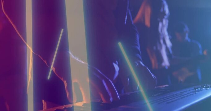 Keyboardist playing synth in live music LED bars sweeping, shot moving closer hands pressing keys
