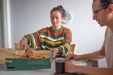 Couple sharing pizza at home for casual lunch
