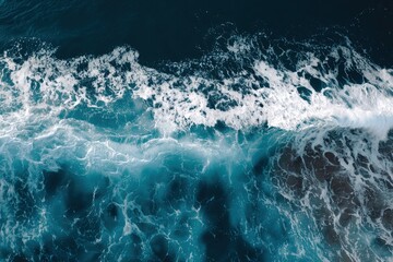Obraz premium Dynamic blue ocean waves with bright foamy details and swirling water patterns from above, idea for nature backgrounds, marine visuals, and coastal design themes