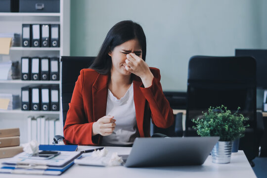 tired business woman sleepy and bored from sitting at a desk for a long time and has office syndrome