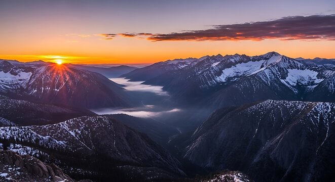 Sunrise over the snowcapped mountains and valley filled with lowlying fog