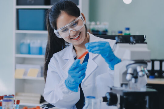 Portrait, science and happy woman on laptop in lab to research chemistry, test or innovation. Microscope, scientist and face of medical doctor in goggles for microbiology, healthcare or pharma study
