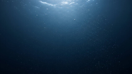 Serene underwater scene with sunlight beams piercing the deep blue ocean, illuminating particles in the vast, tranquil abyss