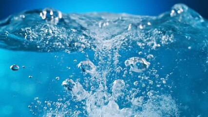 Captivating slow motion of a water splash with dynamic droplets and bubbles rising creating a refreshing and invigorating visual experience for nature and science enthusiasts.