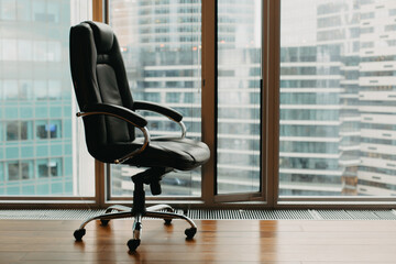 An office chair by the office window in a skyscraper.
