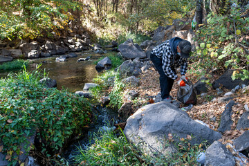 Volunteer Collecting Trash in Autumn Forest – Eco-Friendly Lifestyle and Nature Care