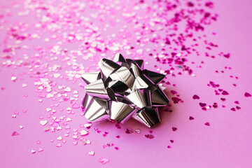 Silver bow on pink background.