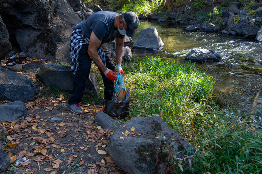 Volunteer Collecting Trash in Autumn Forest – Eco-Friendly Lifestyle and Nature Care - Powered by Adobe
