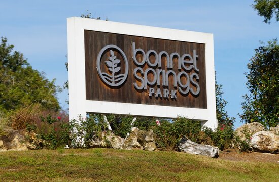 Lakeland, Florida, U.S.A - Nov 10, 2025 - The official welcome sign for Bonnet Springs Park, featuring raised, light-colored lettering on a dark, wood-paneled backdrop.
