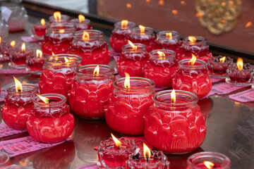 Red candle jar votive with flame, ritual offering and warm glow creating peaceful atmosphere