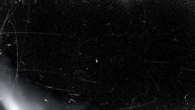 Black background with white scratches and dust particles