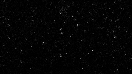 Black background with scattered white dust particles and light speckles