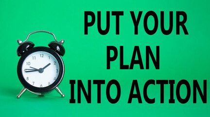 Put your plan into action symbol. Concept words Put your plan into action on white puzzle. Beautiful green background with alarm clock. Business concept and Put your plan into action. Copy space.
