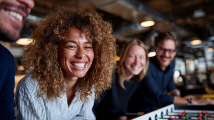 A group of people sitting together at a table in an office environment, smiling and enjoying themselves.