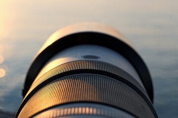 Photographer’s Lens on Pebble Beach at Sunset. Camera Lens Aimed at the Open Sea.
