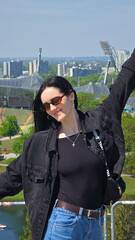 Obraz premium Joyful woman enjoying panoramic city view on sunny day
