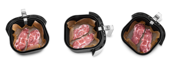 Raw pork neck slices placed in an air fryer basket lined with baking paper, isolated on a transparent background for cooking.