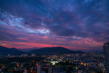 Beautiful view on the night city with beautiful bright sunset sky and colorful clouds.
