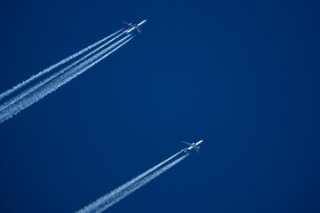 Airplanes in the blue sky. Contrails from two planes flying side by side