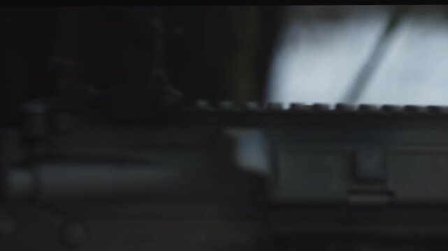 Soldier on a military recon mission in the wilderness. Frozen forest at winter. Close-up aiming with a rifle. Tactical Extension Choke.