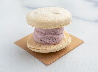A delectable vanilla macaron with berry cream filling evokes pure indulgence. Perfect for showcasing bakery treats and sweet cravings in your designs.