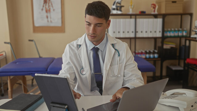 Man doctor in white lab coat with stethoscope typing on digital tablet at clinic building; duty dedication. - Powered by Adobe