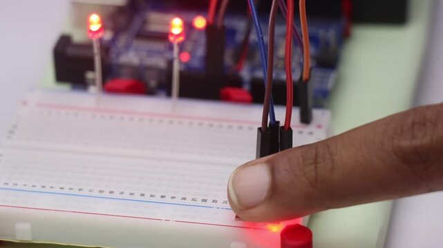 Touch sensor module connected to breadboard that when is touched is activating the red led on background controlled by a microcontroller