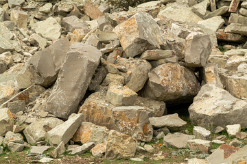 Pieces of rocks are scattered across the mountain surface. Horizontal photo.