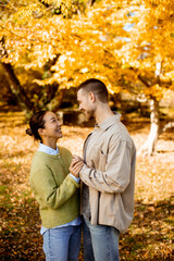 Fototapeta premium Couple shares a joyful moment under golden autumn trees in a park