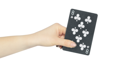 playing card clubs 8 in hand, outstretched hand with black playing card isolated from background