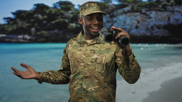 Soldier man in camouflage uniform holding binoculars, open right hand gesture toward sea backdrop in studio; duty pride.