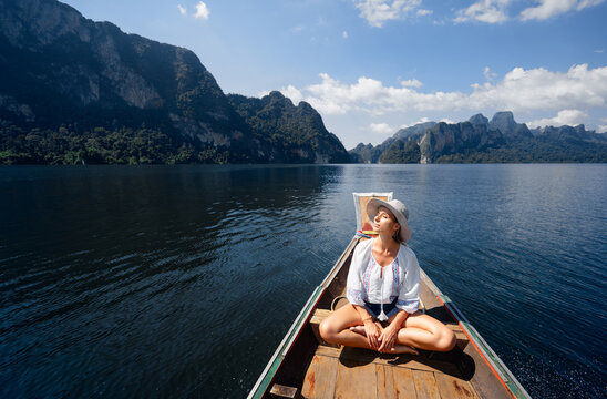 Peaceful Woman Sitting on a Boat in a Serene Mountain Lake - Powered by Adobe