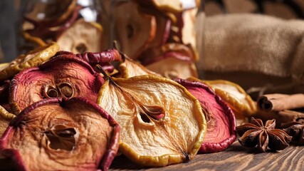 Dried Apple Slices with Cinnamon and Star Anise on Rustic Wooden Table Top Under Bright Warm Light Hand Picking, Close Up Still Life - Powered by Adobe