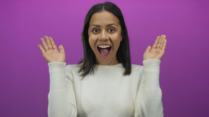 Woman in white sweater smiles with surprise over a vibrant pink background, revealing her cheerful...