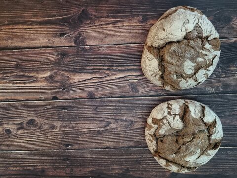 Background of a wooden board with some loaves of bread and copy space