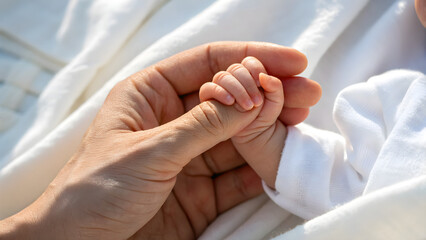 Precious moment of a loving father holding his newborn baby's tiny hand with gentle care, creating a bond of love and security forever