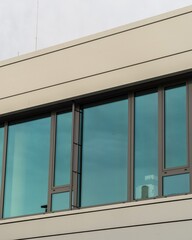 Modern office building exterior featuring large windows reflecting sky