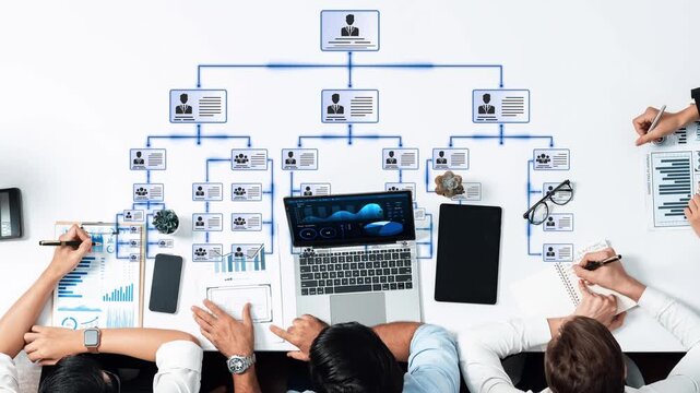 A dynamic workspace showcasing teamwork in analyzing organizational hierarchy. Multiple devices and documents illustrate strategic business planning and management insights. Raster