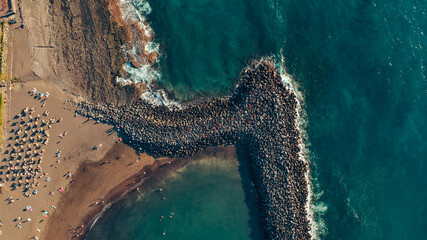 Aerial view of a marine bay with a rock breakwater