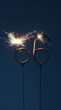 66 number made with sparklers in the form of sixty six on a dark background. Vertical footage.