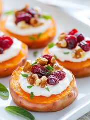 Roasted sweet potato rounds topped with creamy yogurt, walnuts, and cranberries, beautifully arranged on a white plate, showcasing a delicious and healthy appetizer concept
