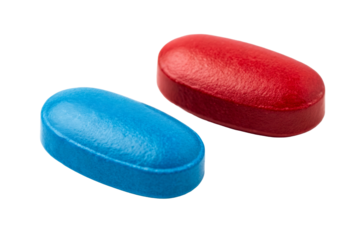 Two different colored pills, blue and red, on a white background representing choices and medication for health and wellness.