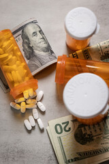 A visually impactful shot featuring prescription pill bottles and scattered US dollar bills (cash). This image symbolizes the high cost and financial burden of medication and the debt caused by health