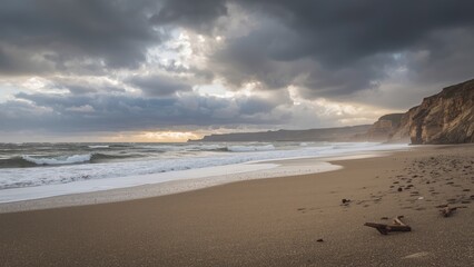 Beach scene with sand, waves, and cliffs under cloudy sky. Weather and coastline landscape. Coastal environment and natural scenery. The scene of a beach coastline with dramatic clouds.