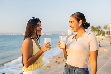 Latin women friends enjoying drinks at sunset in puerto vallarta