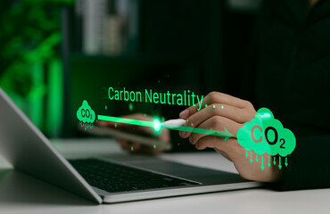 Carbon neutrality concept. Person using laptop with CO2 emission icons and green arrows, representing environmental sustainability, neutral, climate action and net zero carbon footprint strategy.