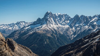 Snow-capped mountain range under clear blue sky with rugged terrain and sharp peaks.