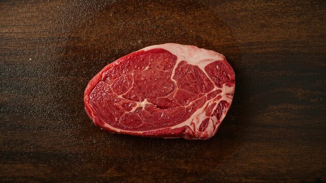 Fresh raw beef steak on a wooden cutting board with marbling and texture. High-quality beef for cooking and meal preparation. - Powered by Adobe